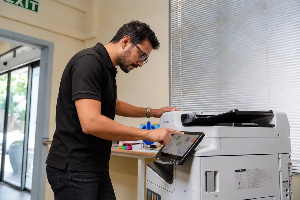 User at the touchscreen of an Epson WorkForce multifunction printer
