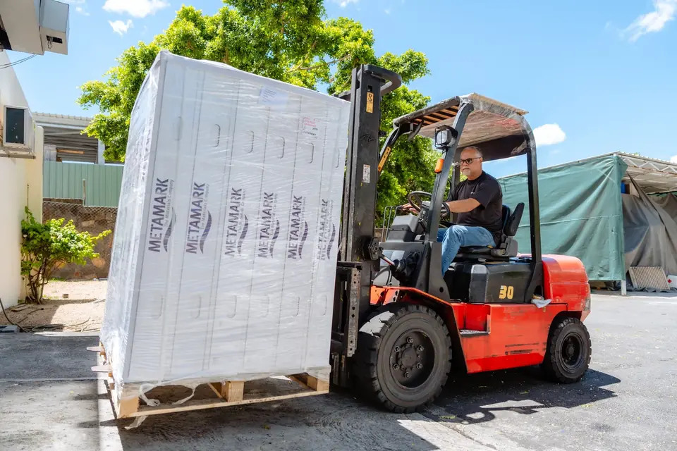 Forklift carrying a pallet of Metamark media