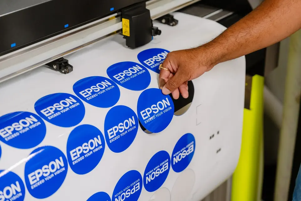 Hand peeling an Epson sticker cut on a Graphtec plotter